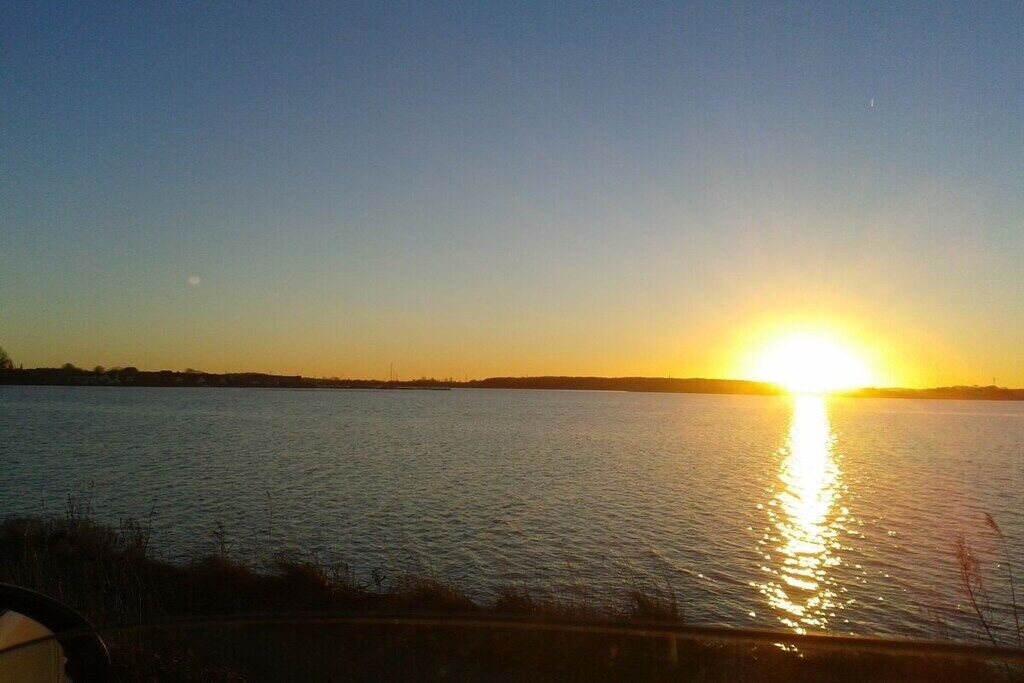 A sunset over a body of water with a clear horizon.