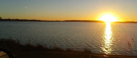 A sunset over a body of water with a clear horizon.