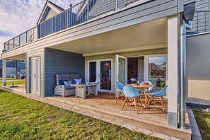 A residential property with a covered patio, outdoor seating, and a visible garage. - Holiday apartment in Büsum with swimming pool (Büsum)