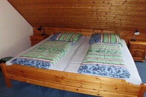 A double bed with a wooden frame and two nightstands on either side. - Holiday home in the North Sea with 3 bedrooms (Wittmund - Carolinensiel)