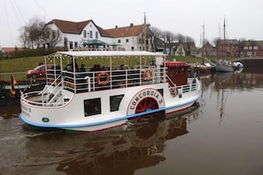 A riverboat with a covered upper deck, passengers, and lifebuoys. - Holiday home in the North Sea with 3 bedrooms (Wittmund - Carolinensiel)