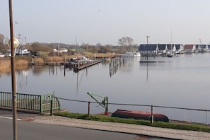 Eine Marina mit vertäuten Booten, einer Rasenfläche und blauem Himmel.