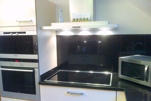 A kitchen with a black stovetop, a microwave, and a built-in oven.