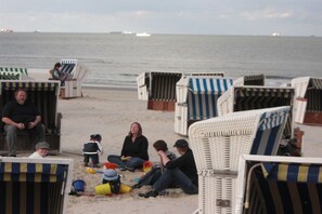 Beach huts with striped awnings, a sandy beach, and the sea in the background. - Holiday apartment with 1 bedroom (Wangerooge)