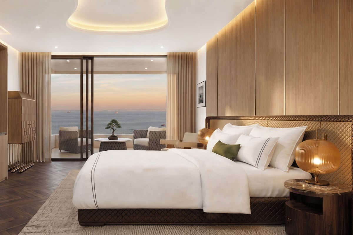 Une chambre d’hôtel moderne dotée d’un grand lit, d’une télévision, d’un bureau et offrant une vue sur la mer.