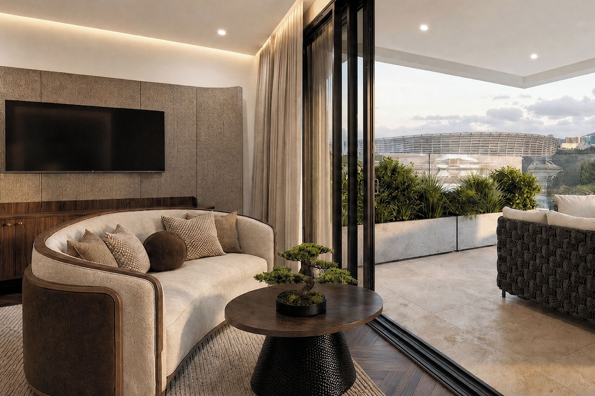 Un salon moderne comprenant un canapé, des fauteuils et une table basse, avec une vue sur le paysage urbain grâce à de grandes fenêtres.
