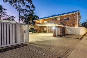A two-story brick house with a covered driveway and a gated entrance. - The Tonic | Teal, Timber & Courtyard, Swan Valley (Bassendean)