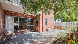 A brick house with a patio, a bench, and a garden with plants and flowers. - The Tonic | Teal, Timber & Courtyard, Swan Valley (Bassendean)