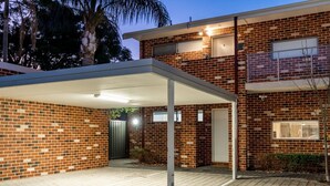 A two-story brick house with a covered driveway and a gated entrance. - The Tonic | Teal, Timber & Courtyard, Swan Valley (Bassendean)