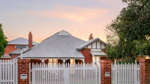 A residential property with a gated entrance, brick walls, and a metal roof. - The Sapphire House | Art Deco, Arcade, Fenced Yard (Inglewood)