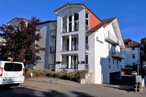A multi-story building with balconies, a white facade, and a red roof. - Beach apartment beach idyll (Ostseebad Binz)