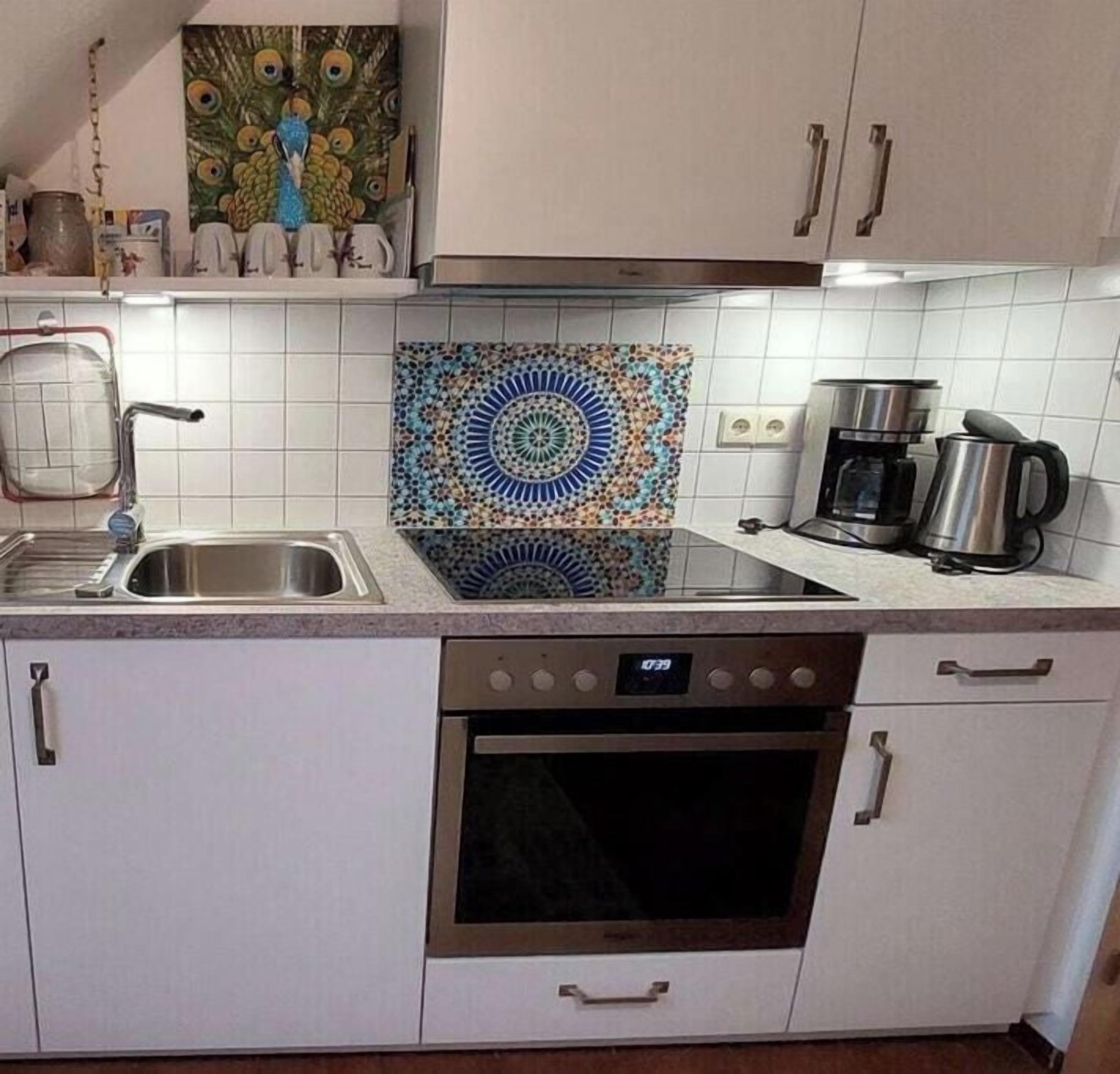 A kitchen with white cabinets, a stainless steel sink, a coffee maker, and a microwave.