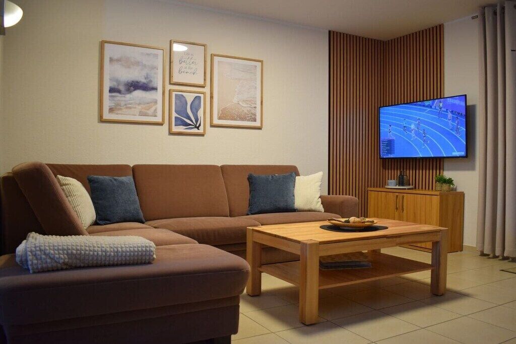 A modern living room with a sofa, a coffee table, and a television.