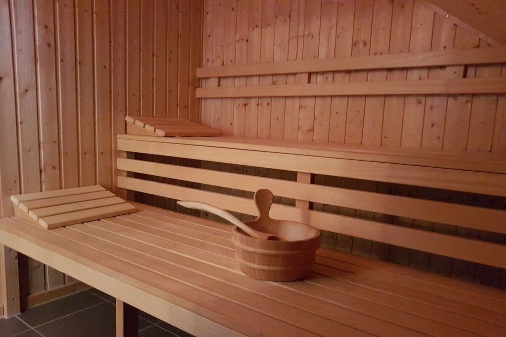 Eine hölzerne Bank mit einem Holz-Eimer und einem Löffel.