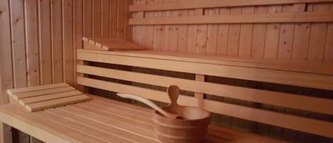 A wooden bench with a wooden bucket and spoon.
