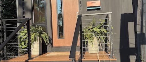 Un bâtiment moderne avec un escalier menant à une porte portant l’inscription « 511, rue Anita Sud ».