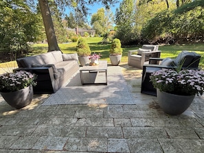 An outdoor patio with a sofa set, a coffee table, and potted plants. - The Modern | 3 BR Upscale Retreat 3 Blocks to IU (Bloomington)