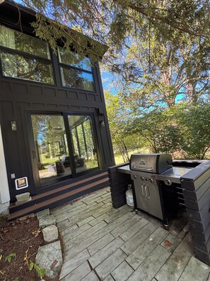 A modern house with a patio, a grill, and a view of the surrounding trees. - The Modern | 3 BR Upscale Retreat 3 Blocks to IU (Bloomington)