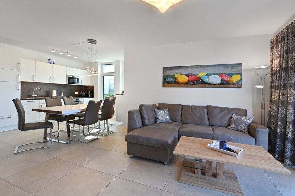 A modern living space with a dining area, a sofa, and a painting on the wall.