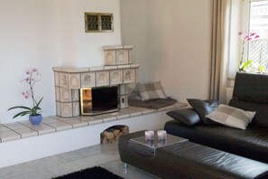 A living room with a fireplace, a sofa, and a coffee table. - "House by the Sea" - Ground Floor (Insel Poel, OT Schwarzer Busch)