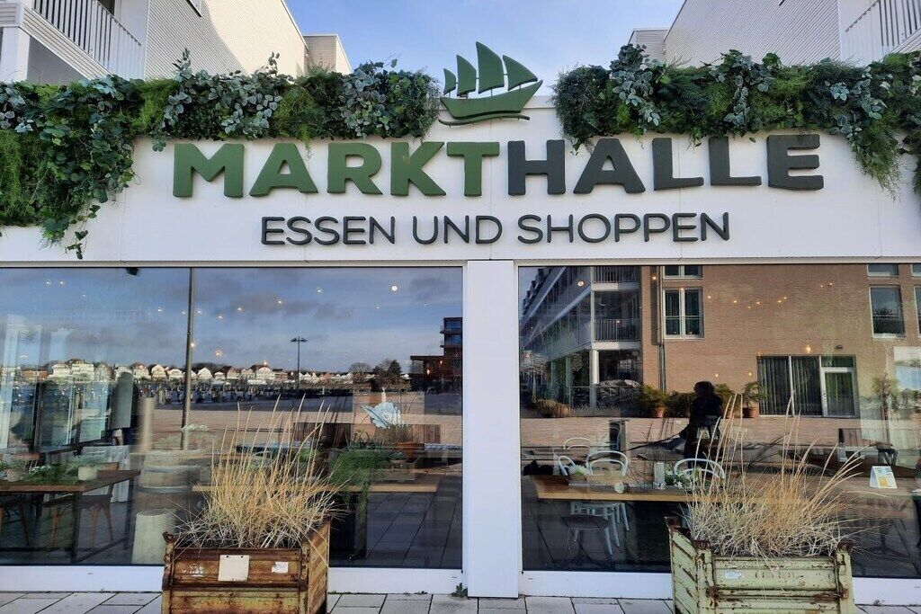 Une devanture de magasin portant le nom « MARKTHALLE » et les mots « ESSEN UND SHOPPEN », indiquant un espace dédié à un marché et à des boutiques.