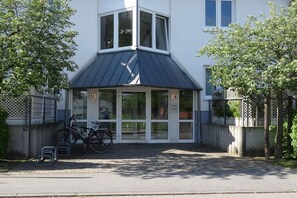 A building with a corner entrance, numbered 16, and a bicycle parked outside. - Travemünde-Priwall - Anchorage (Lübeck Travemünde)
