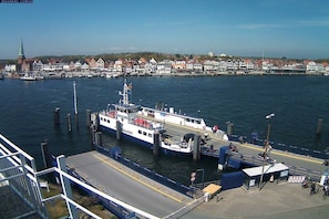 A ferry docked at a pier with a clear view of the town in the background. - Travemünde-Priwall - Anchorage (Lübeck Travemünde)