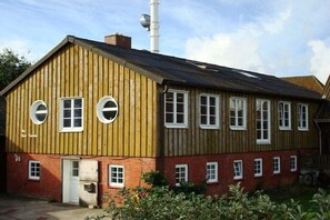 Un edificio de dos plantas con fachada de madera y varias ventanas.