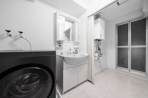 A modern bathroom with a washing machine, a sink, a mirror, and a shower. - Artside Terrace 1001 (Sapporo)