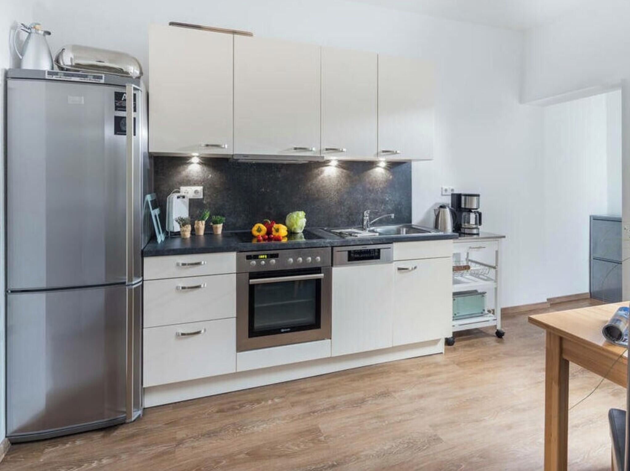 A modern kitchen with stainless steel appliances, a built-in oven, and a coffee maker.