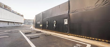 A covered outdoor area with a black tarp, a bicycle rack, and a portable toilet.