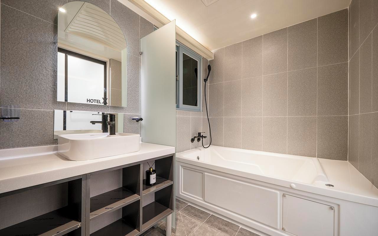 A modern bathroom with a large bathtub, a double sink vanity, and a mirror above the vanity.