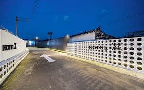 A hotel entrance with a traditional gate and a modern fence with circular cutouts.