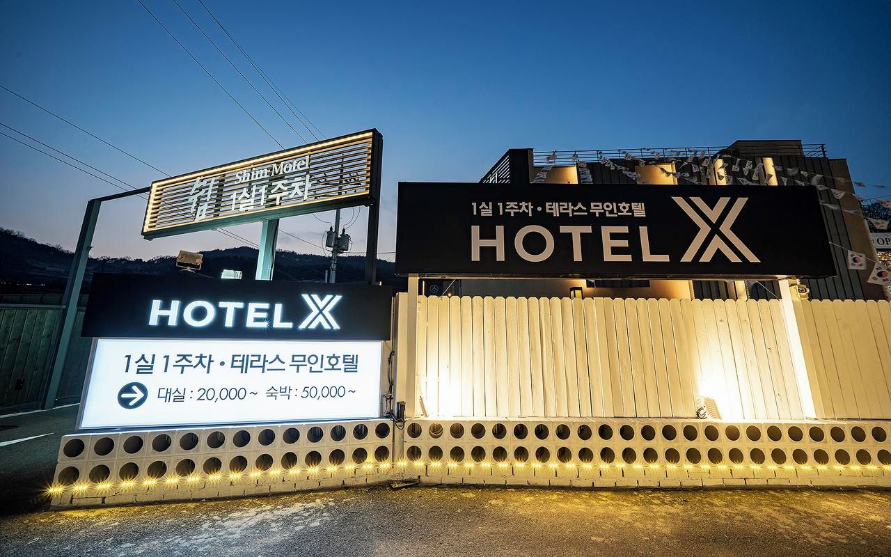 A hotel sign with Korean text and a large illuminated 'HOTEL' sign.
