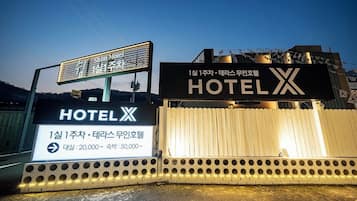 A hotel sign with Korean text and a large illuminated 'HOTEL' sign.