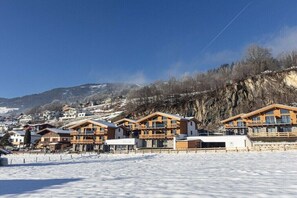 A snow-covered landscape with wooden buildings, likely a ski resort. - Superior Holiday Home # 3B with Sauna (Uttendorf)