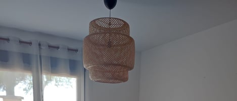 Une chambre à coucher avec un lit, une lampe et une fenêtre avec des rideaux.