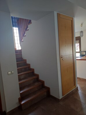 A staircase leading to a landing with a wooden door.