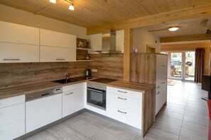 Eine moderne Küche mit weißen Schränken, Holz Arbeitsplatten und einem eingebauten Backofen.