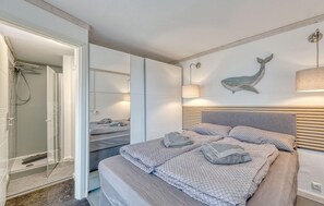 Een moderne slaapkamer met een groot bed, een douche en een wandlamp.