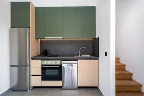 A compact kitchen with a built-in dishwasher, oven, and a stainless steel refrigerator. - Villa located in Kolympia (Rhodes)