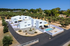 A modern two-story building with a swimming pool, surrounded by trees and a clear sky. - Villa located in Kolympia (Rhodes)