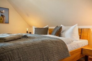 A neatly made bed with a quilt, pillows, and a folded blanket. - Störtebekerstraße 9 - Apartment 6 (Zingst (Ostseeheilbad))