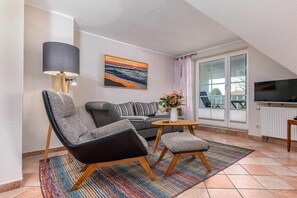 A modern living room with a sofa, two armchairs, a coffee table, and a TV. - Störtebekerstraße 9 - Apartment 6 (Zingst (Ostseeheilbad))