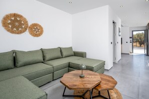 Ein modernes Wohnzimmer mit einer Eckcouch, einem Holztisch und dekorativer Wandkunst.