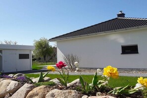 Ein modernes Haus mit weißer Fassade und einem Ziegeldach.