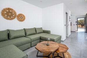 Ein modernes Wohnzimmer mit einer Eckcouch, einem Holztisch und dekorativer Wandkunst.