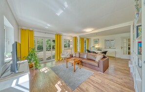 A modern living room with a sofa, coffee table, and a television. - 3 bedroom beautiful apartment in Krems II (Krems II)
