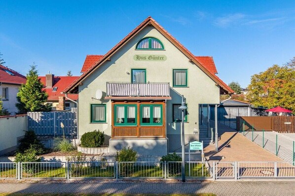 Un edifici tradicional amb teulada inclinada, un balcó i un rètol que diu 'Haus Gintzer'.