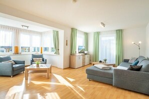 A spacious living room with a sofa set, a coffee table, and a cabinet. - Holiday apartment with 1 bedroom (Ahlbeck (Seebad))